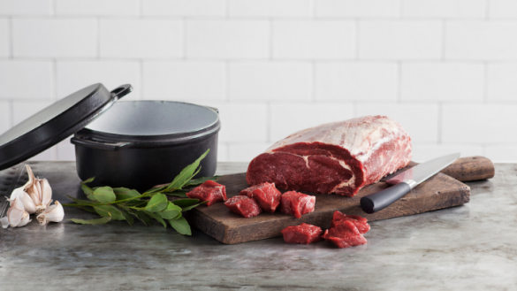 beef-cut-on-wooden-board-with-basil-and-knife