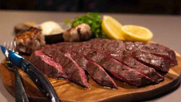 flank steak sliced on a wooden board